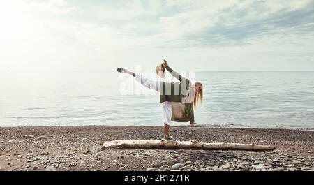 La nature met tout en équilibre. une jeune femme marchant le long d'une bûche à un lac. Banque D'Images