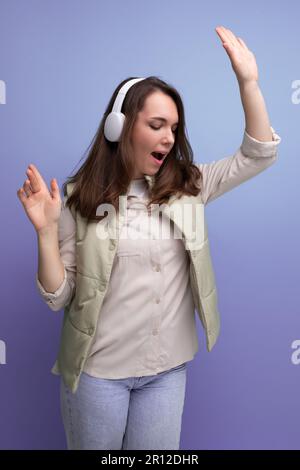 jeune femme de brunette énergique se détendant à la musique en utilisant le casque et le téléphone portable Banque D'Images