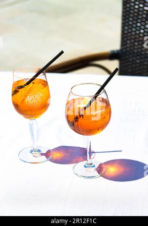 Apéritif Spritz et Campari Orange cocktails avec des tranches d'orange et de la glace dans des verres à vin sur une table de restaurant sur la côte de la mer par une journée ensoleillée. Vacances c Banque D'Images