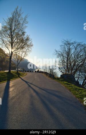 Parking donnant sur la route, le Nordfjord et Bergen en Norvège. Les rayons du soleil tombent à travers les arbres. Paysage de Scandinavie Banque D'Images