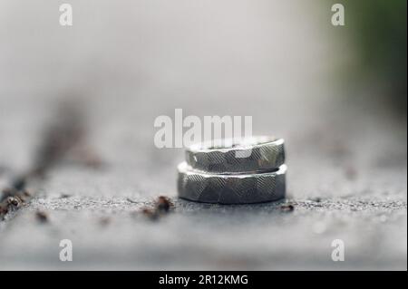 Les deux bracelets de mariage brillants en argent reposent sur une surface plane. Banque D'Images
