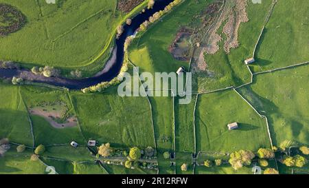 Vue aérienne sur la rivière Ure qui serpend dans les terres agricoles lors d'une soirée de printemps dans les Yorkshire Dales près de Hawes, au Royaume-Uni. Banque D'Images