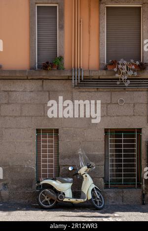 Une mobylette blanche garée à l'extérieur d'un bâtiment à Pitigliano, en Italie. Banque D'Images