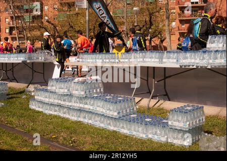 Des bouteilles d'eau en plastique s'empilent pour les personnes qui exécutent le marathon de Barcelone dans les rues urbaines lors d'une journée chaude et ensoleillée en Espagne Banque D'Images