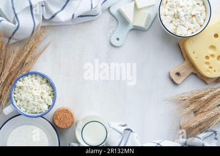 Fête juive de Shavuot. Kasher produits laitiers frais lait et fromage, blé mûr, crème sur fond de bois blanc. Les produits laitiers sur le whi Banque D'Images