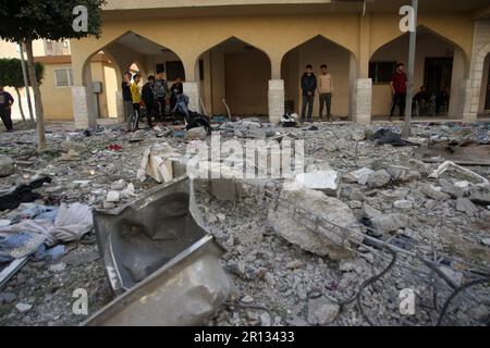 Les Palistins se promènaient au milieu de débris devant le bâtiment abritant le plat (dernier étage) d'un chef militaire du Jihad islamique, détruit par une attaque aérienne israélienne à Khan Yunis dans la bande de Gaza, à Thunsday 11 mai 2023. L'armée israélienne et les militants de Gaza ont échangé de lourds tirs transfrontaliers du jour au lendemain, avec au moins 25 Palestiniens tués sur deux jours. Photo par Ismael Mohamad/UPI crédit: UPI/Alay Live News Banque D'Images