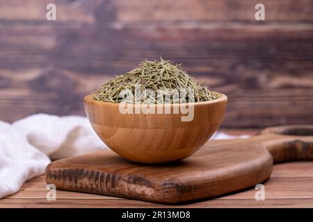 Feuilles de romarin aux herbes séchées. Assaisonner le romarin sur fond de bois. Épices et herbes pour la cuisine, herbes de provence Banque D'Images