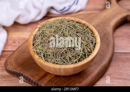 Feuilles de romarin aux herbes séchées. Assaisonner le romarin sur fond de bois. Épices et herbes pour la cuisine, herbes de provence Banque D'Images