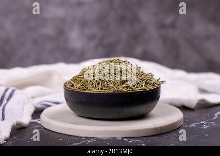 Feuilles de romarin aux herbes séchées. Assaisonner le romarin sur fond sombre. Épices et herbes pour la cuisine, herbes de provence Banque D'Images