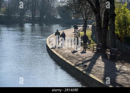 Personnes marchant le long du bord de la rivière Wye à Bakewell, Derbyshire, Angleterre Banque D'Images