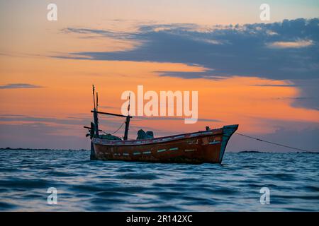 Vue sur le coucher du soleil avec ciel nuageux à la plage de Gadani avec bateau à how Banque D'Images