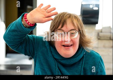 Portrait d'une joyeuse femme de 40 ans avec le syndrome de Down agitant et souriant, Tienen, Belgique Banque D'Images