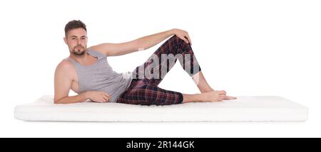 Homme allongé sur un matelas doux sur fond blanc Banque D'Images