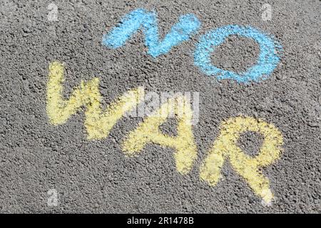 Mots No War écrit avec des craies bleues et jaunes sur l'asphalte à l'extérieur Banque D'Images