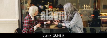 Deux femmes heureuses prenant un café au café Banque D'Images