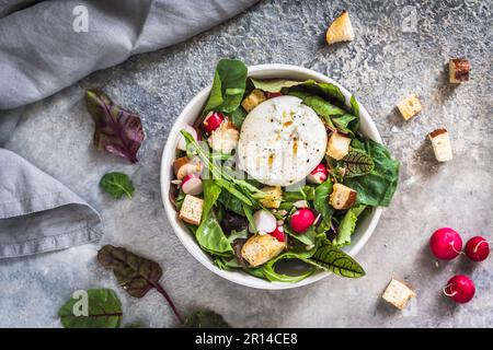 Salade mixte avec radis, croûtons faits maison et fromage burrata sur fond gris, vue de dessus Banque D'Images