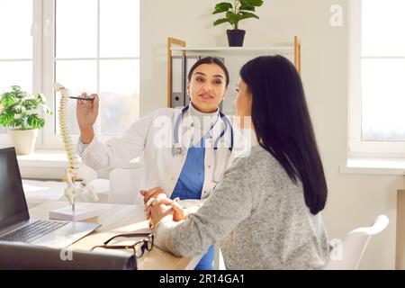 Médecin physiothérapeute donnant la consultation sur la scoliose ou les problèmes de la colonne vertébrale à la patiente. Banque D'Images