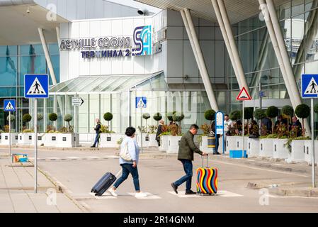 Couple de passagers sur le passage de zébra ou passage de passage à côté de l'aéroport calme et vide de Sofia à Sofia, Bulgarie, Europe de l'est, Balkans, UE Banque D'Images