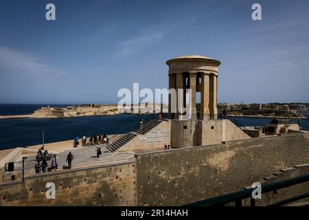 Valette, Malte - 20 avril 2023 : touristes visitant un siège de la Bell sur la côte de la mer. Banque D'Images