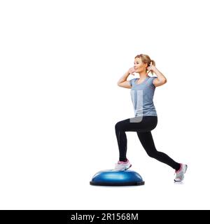 Elle suit un plan d'exercice strict. Une jeune femme attirante lapira ses cuisses sur un bosu-ball. Banque D'Images