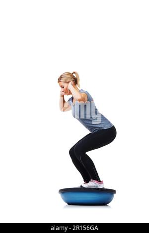 Elle suit un plan d'exercice strict. Une belle jeune femme debout sur un bosu-ball tout en s'entraîner. Banque D'Images