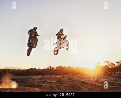 Aventure, vitesse et moto pour une compétition pendant une course en plein air pour les sports extrêmes. Action, hommes et moto sur piste de course pour le saut sportif Banque D'Images