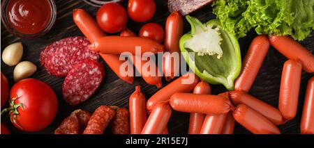 Différents types de saucisses et de légumes sur fond de bois sombre Banque D'Images