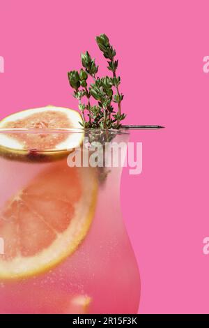 Cocktail d'été frais avec figue, pamplemousse et thym près de la paroi rose Banque D'Images