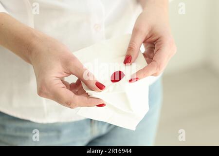 La femme tient des mouchoirs en papier tachant du sang dans la pièce lumineuse Banque D'Images