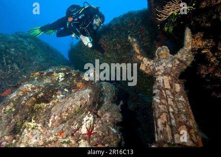 Plongeur à côté de la statue du Christ, Europe, Porto, site de plongée le Scole, île sous-marine de Giglio, Toscane, Italie Banque D'Images