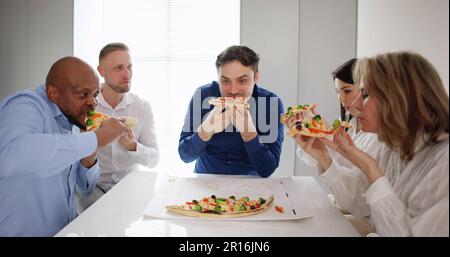 Groupe d'amis multiethniques Eating Pizza Together Banque D'Images