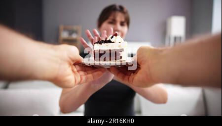 Femme refusant tranche de gâteau délicieux offerts par une personne Banque D'Images