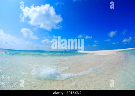 Jet de mer, plage de Hatenohama, nuages fleurés et vue lointaine de l'île de Kumeshima, fisheye Banque D'Images