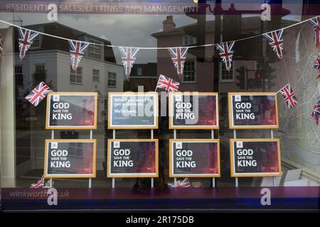 La signalisation God Save the King dans la fenêtre de la boutique d'un agent immobilier présentant Royal Coronation Celebration Bunting et Union Jacks, Londres, Angleterre, Royaume-Uni Banque D'Images