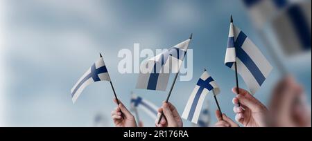 Un groupe de personnes portant entre leurs mains de petits drapeaux de la Finlande. Banque D'Images
