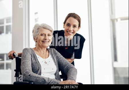 Elle prend bien soin de ses patients. une infirmière qui s'occupe d'une femme âgée en fauteuil roulant. Banque D'Images