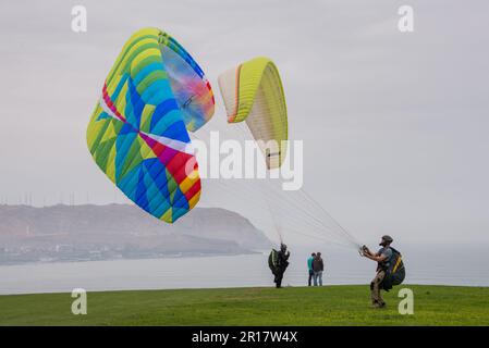 Les gens sur le point de décoller avec leurs parapentes dans les falaises Banque D'Images