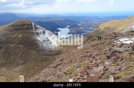 Marcheurs près du sommet de Sail Gharbh, l'un des 3 sommets de Quinag à Assynt, en Écosse. Vue ouest vers la côte. Suilven Beyond (à l'extrême gauche). Banque D'Images