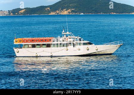 Ferry blanc vide pour les Cinque Terre (bateau d'excursion) en face de l'ancien village de Tellaro, mer Méditerranée, golfe de la Spezia, Ligurie. Banque D'Images