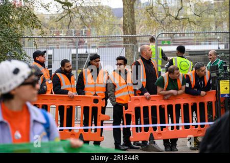 LONDRES - 22 avril 2023 : les ouvriers du bâtiment en vestes haute visibilité d'un chantier voisin observent la manifestation de la rébellion d'extinction de derrière un b Banque D'Images