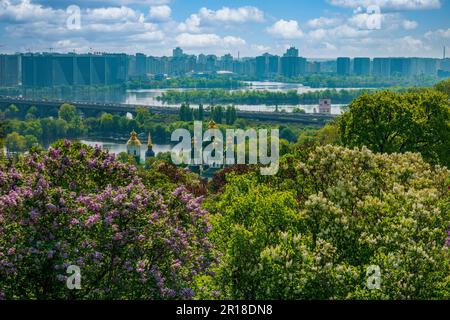 Vue emblématique sur la rive gauche de la ville de Kiev depuis le jardin botanique. Vue sur la ville de Kiev au printemps. Le monastère de Vydubitskyi est entouré de lilas en fleurs. Rivière Dnipro Banque D'Images