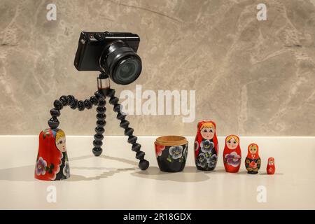 Un petit appareil photo numérique noir jouant avec des poupées Matryoshka Banque D'Images