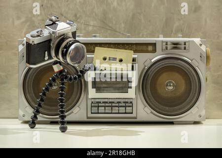 Une vieille caméra mettant une cassette dans une boombox Banque D'Images