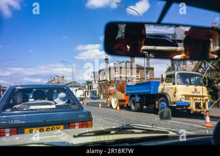 Une vue à travers un pare-brise de voiture dans la périphérie de 1980s Glasgow, Royaume-Uni Banque D'Images