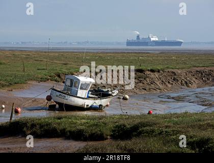 Bateau de pêche à marée basse à Stone Creek (avec cargo à distance), île de Snoyl, East Yorkshire, Angleterre Royaume-Uni Banque D'Images