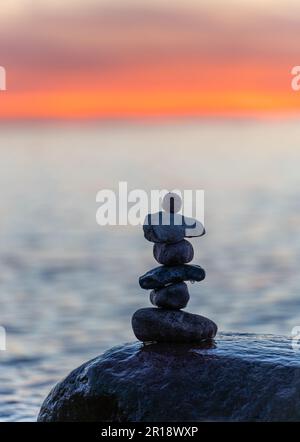 Pyramides en pierre sur la plage de sable de la mer Baltique à Rügen jusqu'au spectaculaire coucher de soleil orange Banque D'Images