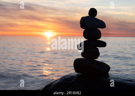 Pyramides en pierre sur la plage de sable de la mer Baltique à Rügen jusqu'au spectaculaire coucher de soleil orange Banque D'Images