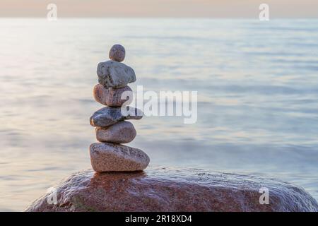 Pyramides en pierre sur la plage de sable de la mer Baltique à Rügen jusqu'au spectaculaire coucher de soleil orange Banque D'Images