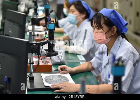 Suqian, Chine. 11th mai 2023. SUQIAN, CHINE - 11 MAI 2023 - les travailleurs produisent des composants électroniques sur une chaîne de production dans une usine d'électronique à Suqian, dans la province de Jiangsu, en Chine orientale, au 11 mai 2023. (Photo par Costfoto/NurPhoto) crédit: NurPhoto SRL/Alay Live News Banque D'Images