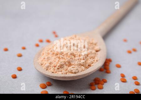 Cuillère de farine de lentilles et de graines sur table blanche, gros plan Banque D'Images